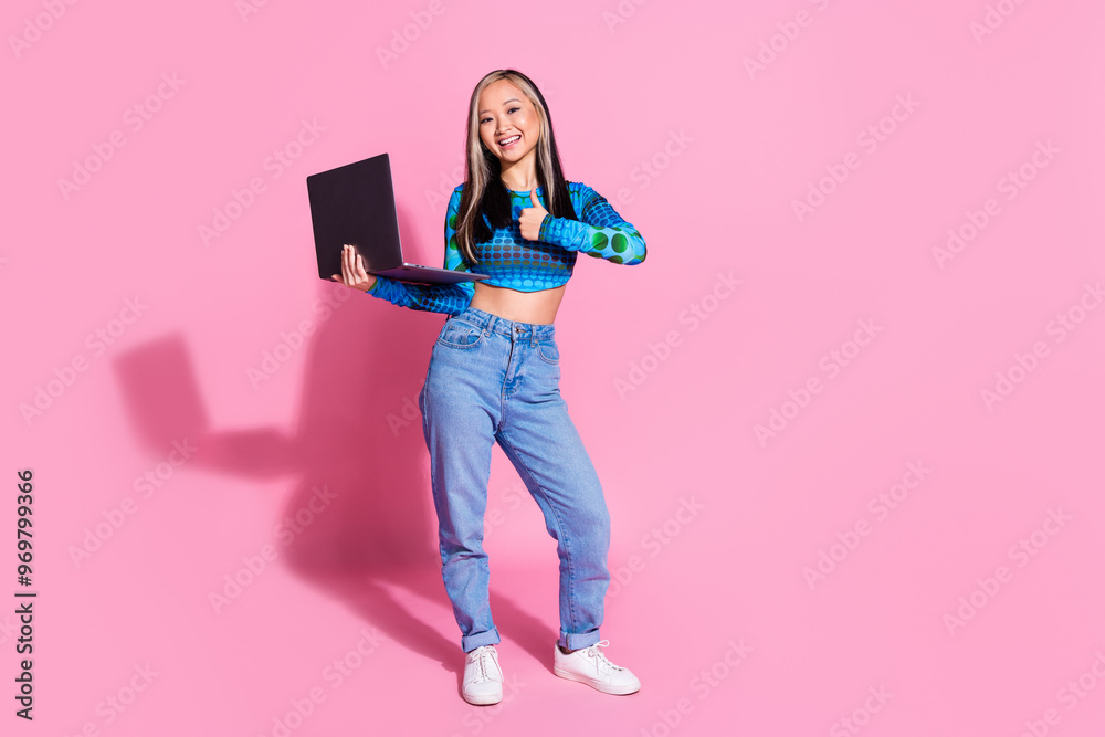 Photo of charming positive woman wear blue top showing thumb up read modern gadget empty space isolated pink color background Photo of charming positive woman wear blue top showing thumb up read modern gadget empty space isolated pink color background