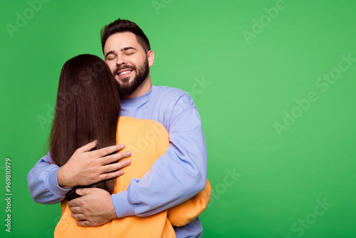 Back view photo of charming lovely couple wear stylish clothes empty space isolated on green color background photo