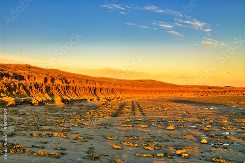 Fiery red eroded rocks at sunset at the coast of Cape Keraudren, a remote area between Port Hedland and Broome in Western Australia.Rocky beach with small pools. Part of Eighty Mile Beach Marine Park. photo