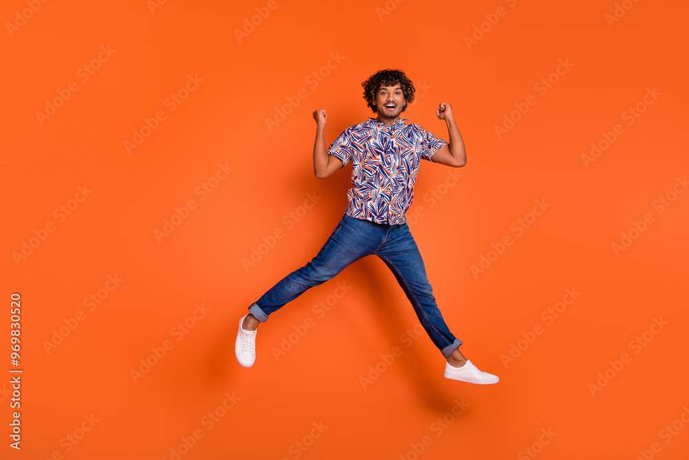 Full size photo of nice young man running winning wear trendy colorful outfit isolated on orange color background Full size photo of nice young man running winning wear trendy colorful outfit isolated on orange color background