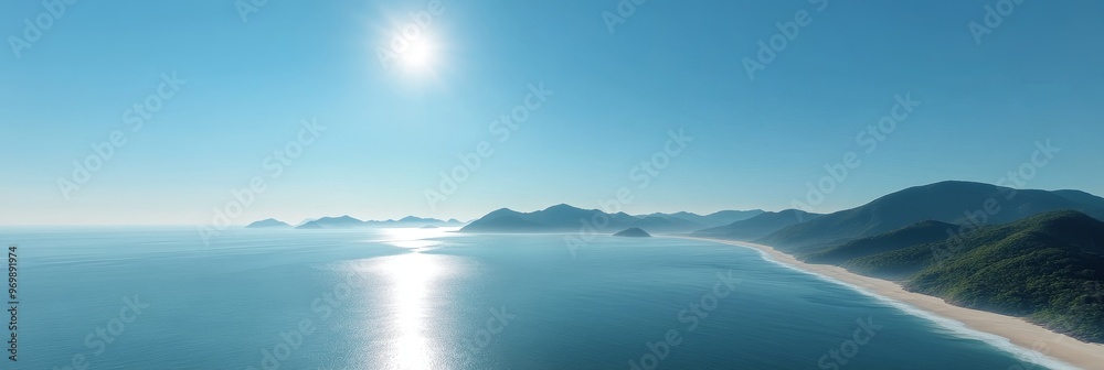 This aerial photograph captures the breathtaking beauty of a serene coastal landscape. The image showcases a long, sandy beach bordering a tranquil ocean, with rolling green hills rising in the distan This aerial photograph captures the breathtaking beauty of a serene coastal landscape. The image showcases a long, sandy beach bordering a tranquil ocean, with rolling green hills rising in the distan