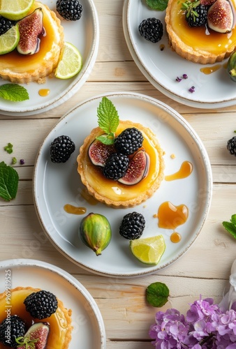 Delicious fruit tart with figs, blackberries, and lime on a wooden table