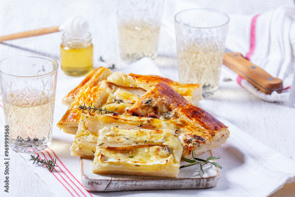 Puff pastry pie with cheese, pears, nuts and honey, served with champagne.