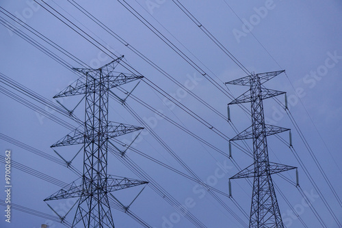 Photo of a high-voltage power transmission tower as the sun sets.