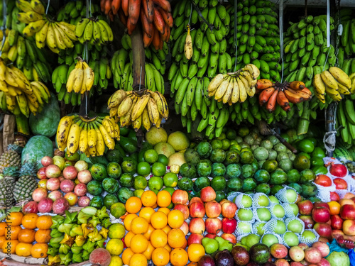 Colourful fruits and vegetables in a market place in Kandy, Sri Lanka. Banana, apple, orange, avocado, watermelon, pear, pineapple, melon.