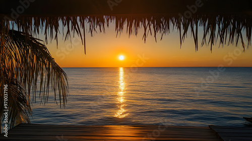 A serene ocean view from a beachfront bungalow with the sun setting over the calm water and casting a golden reflection.