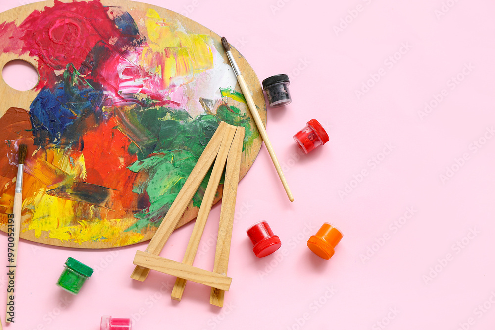 Palette with brushes and paints on pink background Palette with brushes and paints on pink background