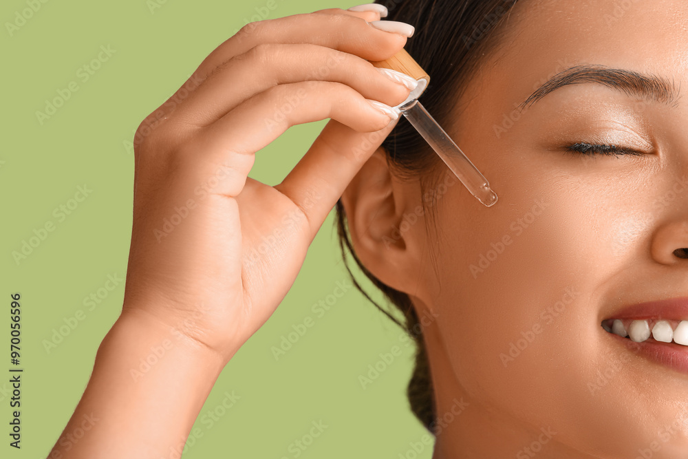 Beautiful Asian woman with serum on green background, closeup Beautiful Asian woman with serum on green background, closeup