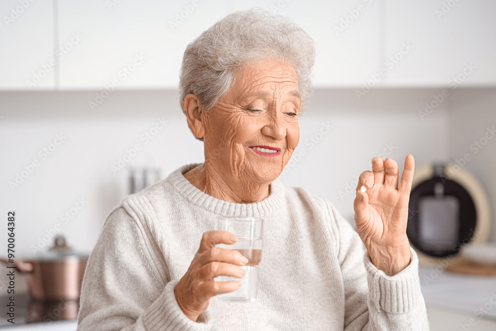 Senior woman with pill and glass of water in kitchen, closeup Senior woman with pill and glass of water in kitchen, closeup