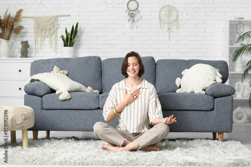 Young woman meditating at h...
