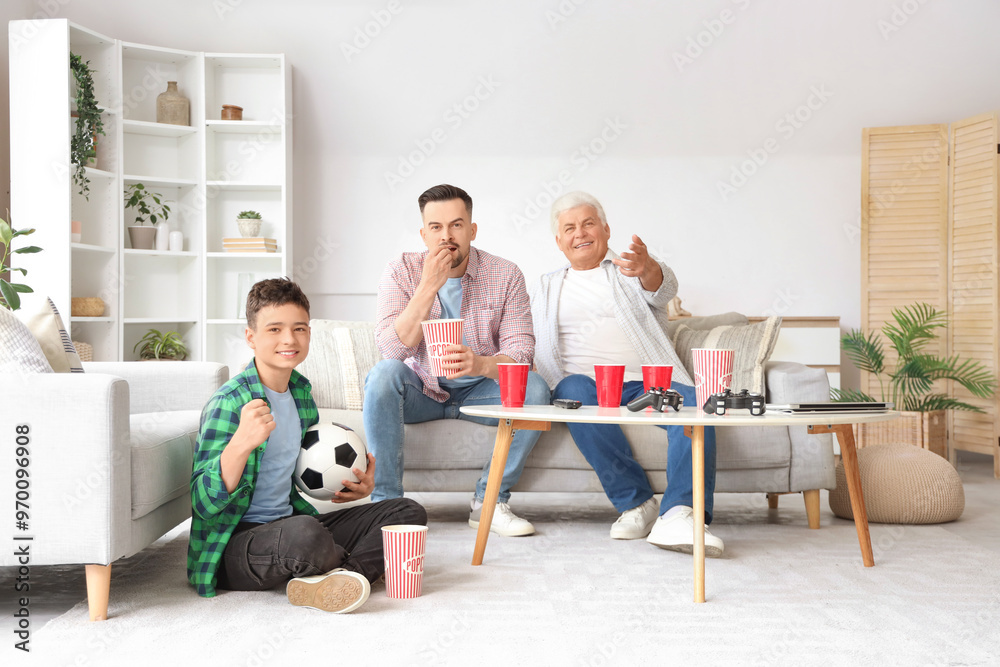 Φωτογραφία Teenage boy with his dad and grandfather watching football at home