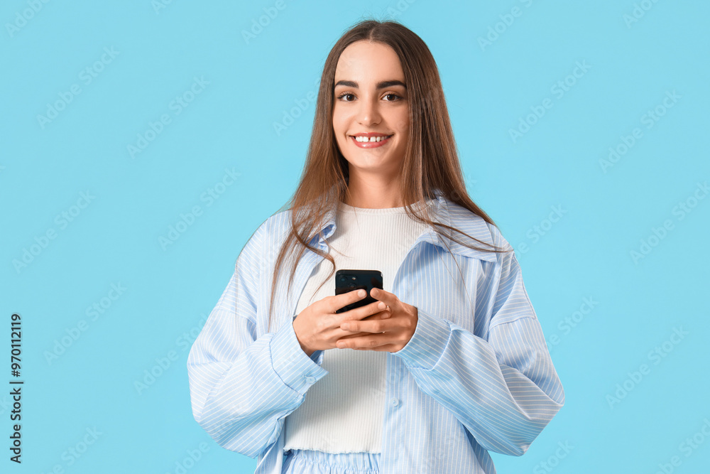 Young beautiful woman with mobile phone on blue background Young beautiful woman with mobile phone on blue background