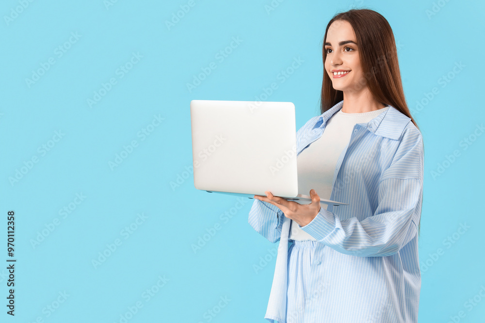 Young beautiful woman using laptop on blue background Young beautiful woman using laptop on blue background