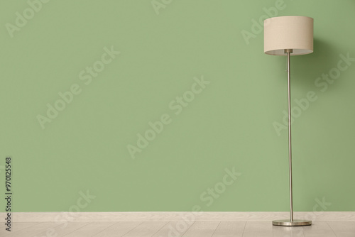 Floor lamp near green wall in room