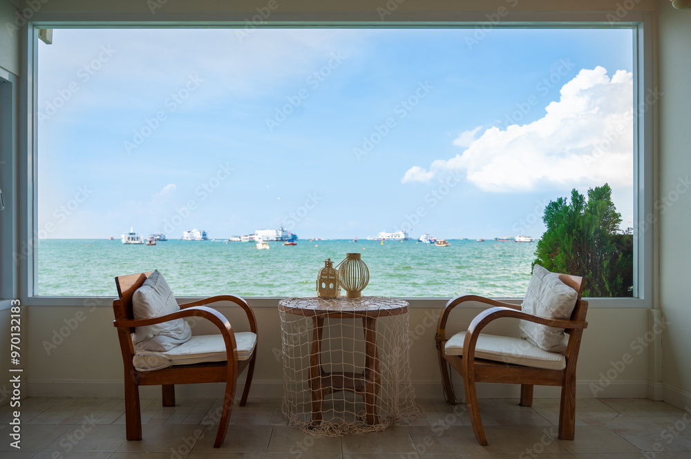 Two chairs by a large window overlooking the sea Two chairs by a large window overlooking the sea