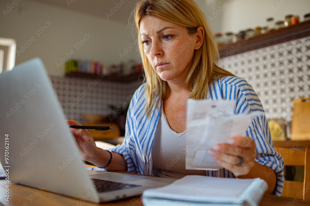Woman feeling stressed while reading bills at home Woman feeling stressed while reading bills at home