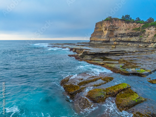 Sunrise seascape and rocky Inlet with thick fog cloud over the ocean photo