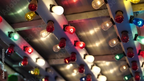 colorful light bulbs arranged in rows on a metal structure, likely part of a carnival or fair booth