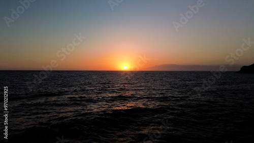A quiet sentinel by the sea  its light shining across the vast expanse of water  surrounded by cliffs and rocky shores