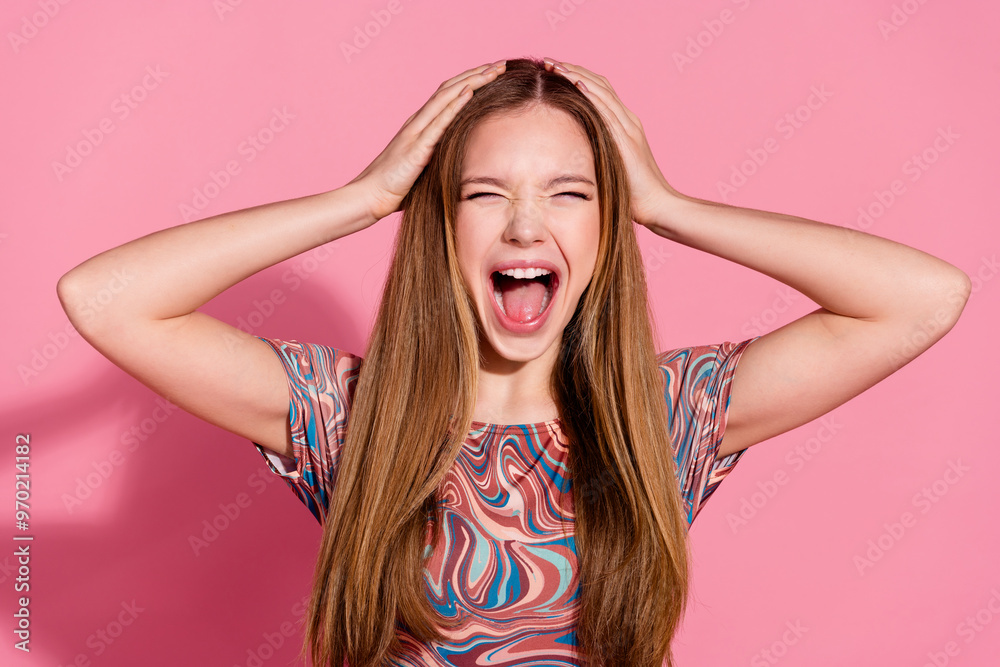 Portrait of crazy furious teen with long hairstyle wear colorful t-shirt hands on head loudly screaming isolated on pink color background Portrait of crazy furious teen with long hairstyle wear colorful t-shirt hands on head loudly screaming isolated on pink color background