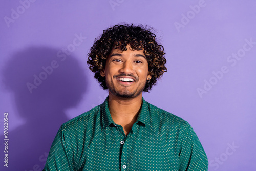 Photo portrait of funny optimistic smiling handsome arabian guy with wavy haircut wearing green casual shirt isolated on violet color background