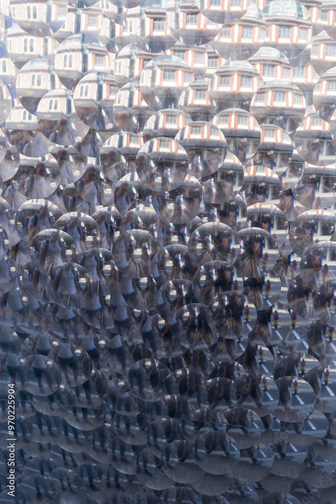 Fototapeta premium Kaleidoscopic reflection of city buildings and passersby