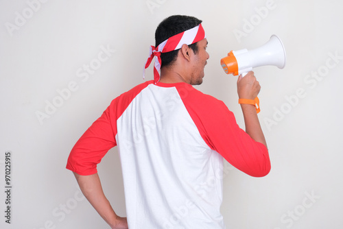 Back view of Indonesian man talking using megaphone photo