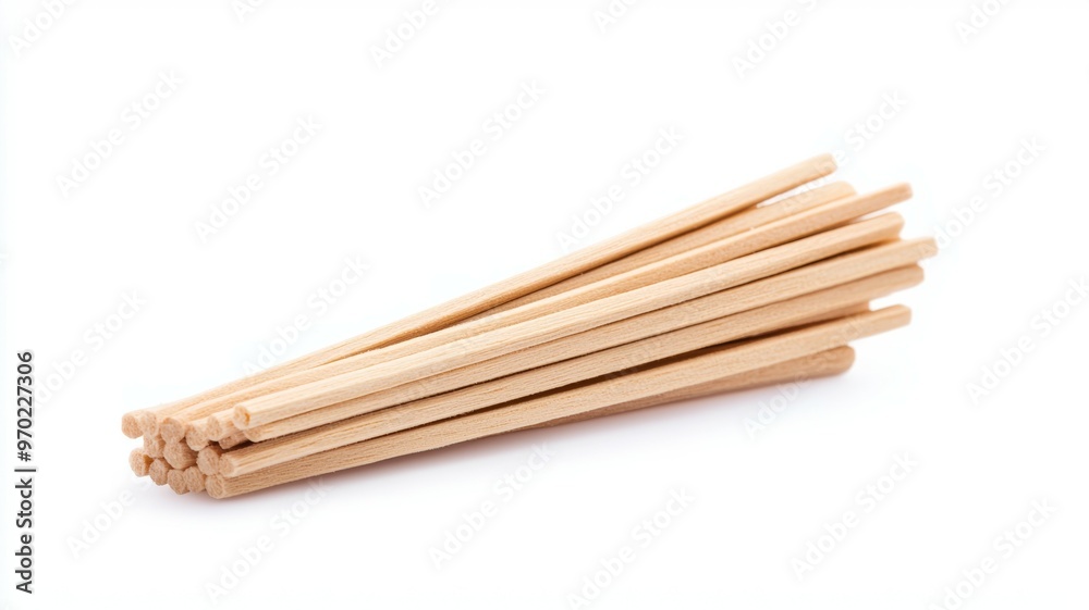 A bunch of wooden chopsticks are sitting on a white background A bunch of wooden chopsticks are sitting on a white background