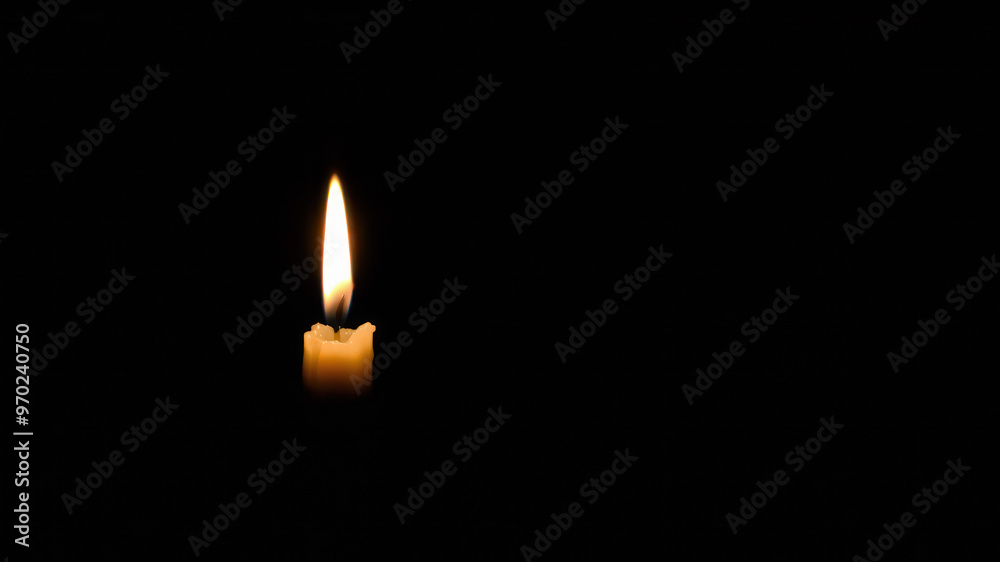 Halloween background with single candle flame in darkness Halloween background with single candle flame in darkness
