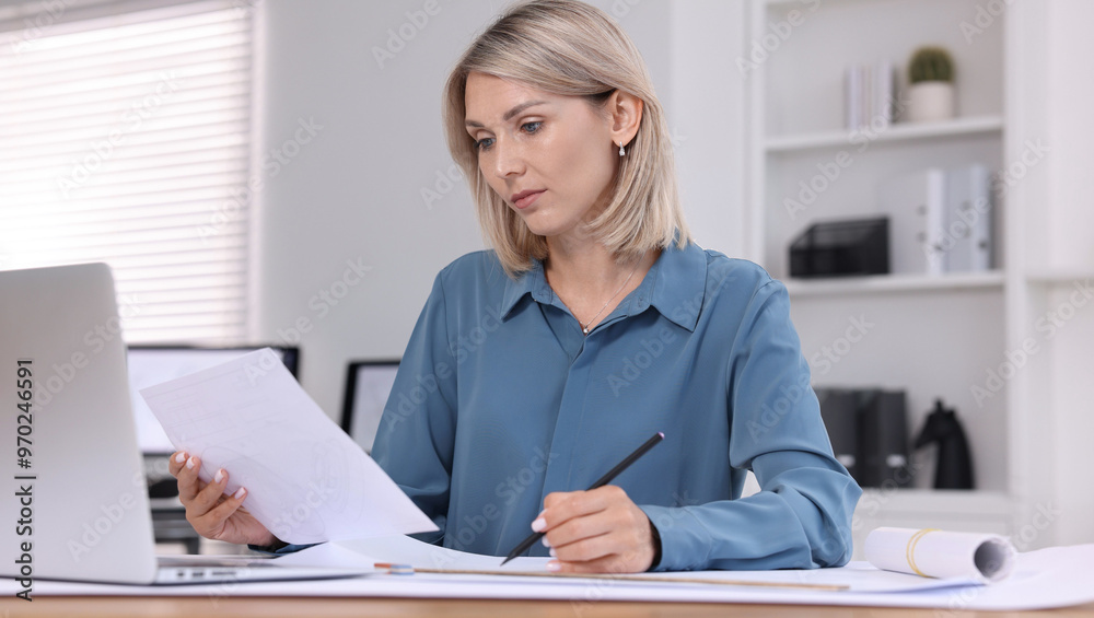 Architect making engineering drawing at table in office Architect making engineering drawing at table in office