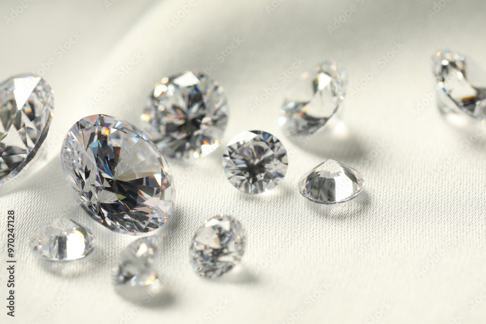 Many beautiful shiny diamonds on white fabric, closeup Many beautiful shiny diamonds on white fabric, closeup