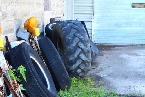 Large tires piled by garage 