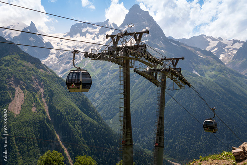 View of the supports of the Dombay ski resort cable car on the background of the Caucasus Mountains on a summer day, Karachay-Cherkessia, Russia photo