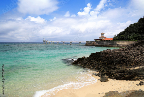 Okinawa, Japan - June 5, 2019: Bathing beach and rocks with the background of Undersea Observatory and horizon at Busena Marine Park photo