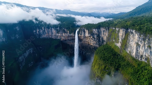 Aerial view of a waterfall cascading into a deep canyon, with mist rising from below, waterfall cascade, breathtaking landscape aesthetic