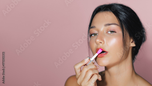 Wallpaper Mural Latina Woman Applying Pink Lipstick in Beauty Close-Up Against Pink Background Torontodigital.ca