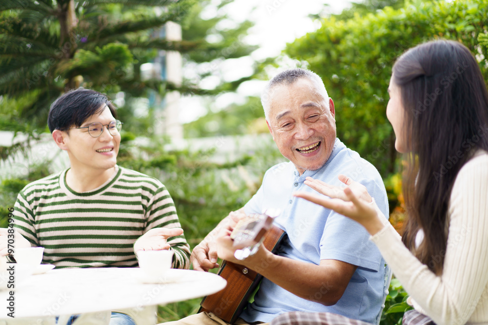 Happy Asian family spending time together, man and woman let their father playing a guitar and singing in backyard garden at home. Mental health care and wellbeing in senior adult. Happy Asian family spending time together, man and woman let their father playing a guitar and singing in backyard garden at home. Mental health care and wellbeing in senior adult.