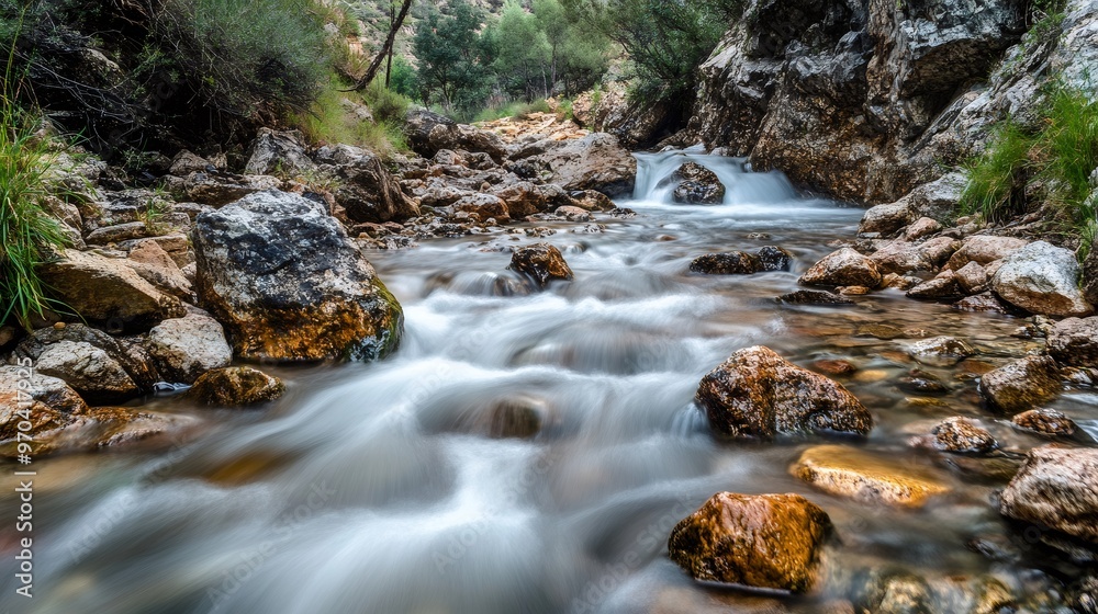 A mountain stream rushes over smooth rocks with a long exposure shot. A mountain stream rushes over smooth rocks with a long exposure shot.