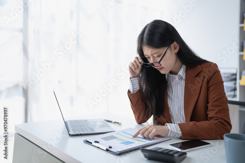 Valokuva businesswoman plans a finance audit, reviewing documents while battling burnout syndrome