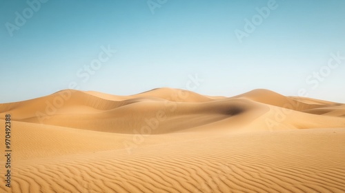 A serene desert landscape with golden dunes stretching far beneath a cloudless cerulean sky, emphasizing the vast openness.