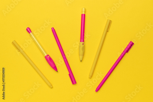 Bright Yellow and Pink Pens Arranged on Vibrant Yellow Background for Creative Stationery Design