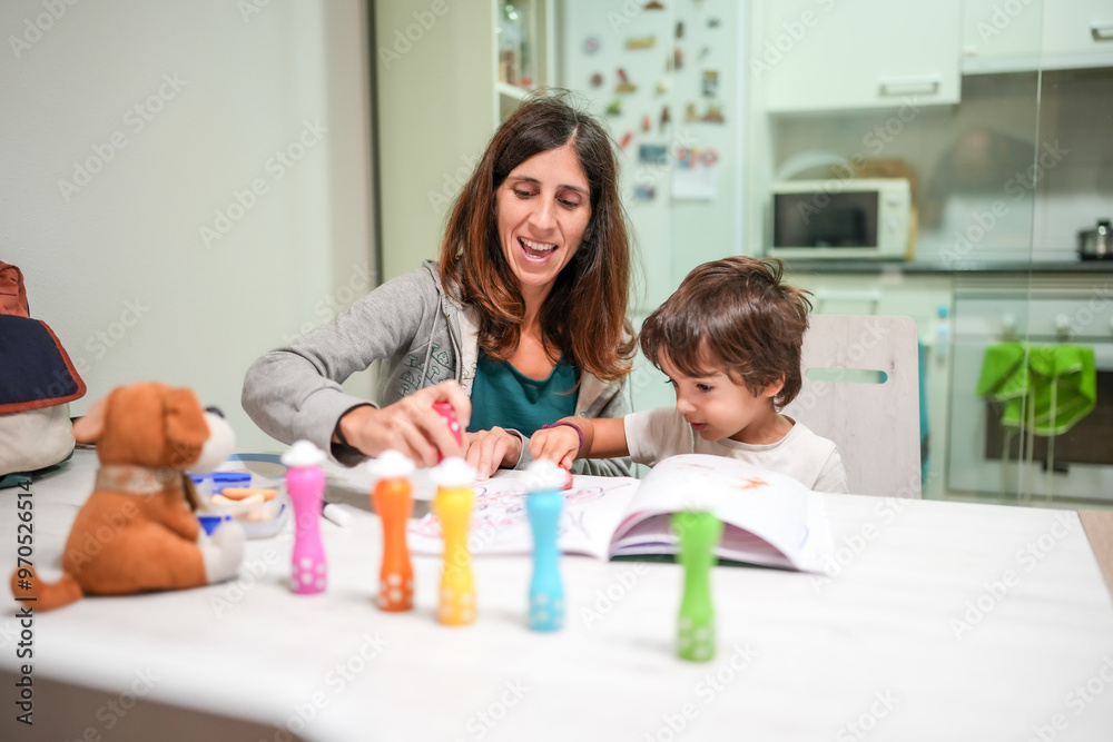 Fototapeta premium A woman and a child are sitting at a table with a book