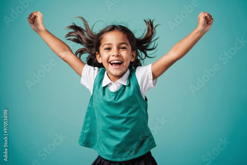 cheerful school child girl jumping  on turquoise background photo