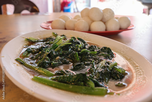 Asian Malaysian style sauté fired spinach with garlic at local restaurant outdoors photo