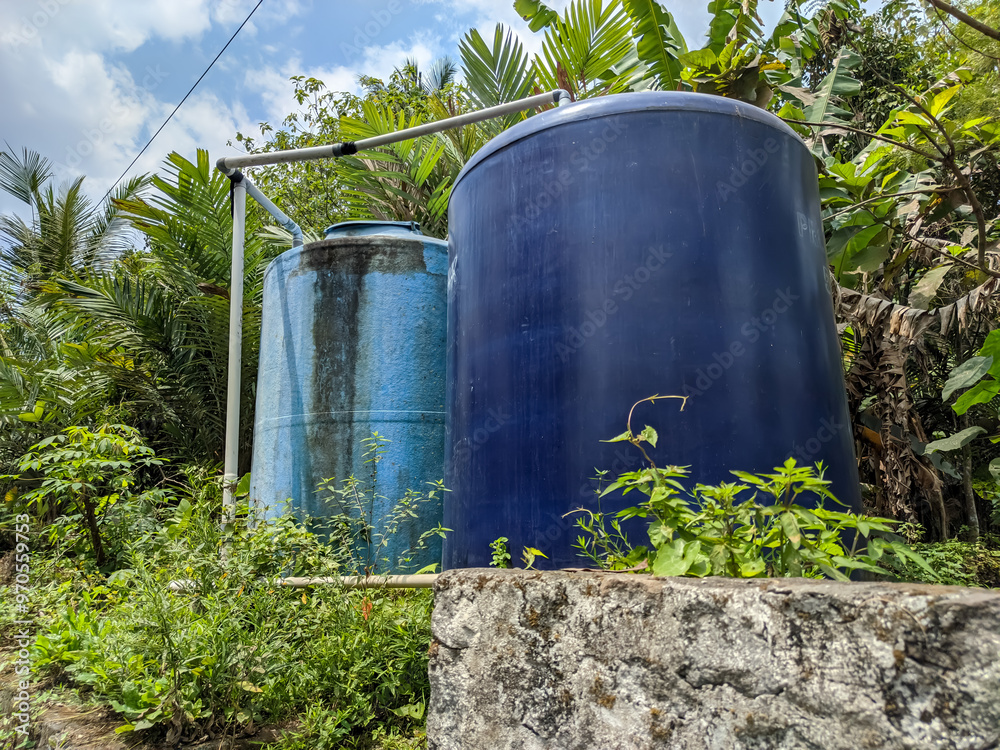 A striking pair of water tanks dominate the landscape. One, a deep navy blue, stands as a sturdy and imposing figure. Beside it, a tank in a cheerful sky blue hue offers a playful contrast.
A striking pair of water tanks dominate the landscape. One, a deep navy blue, stands as a sturdy and imposing figure. Beside it, a tank in a cheerful sky blue hue offers a playful contrast.