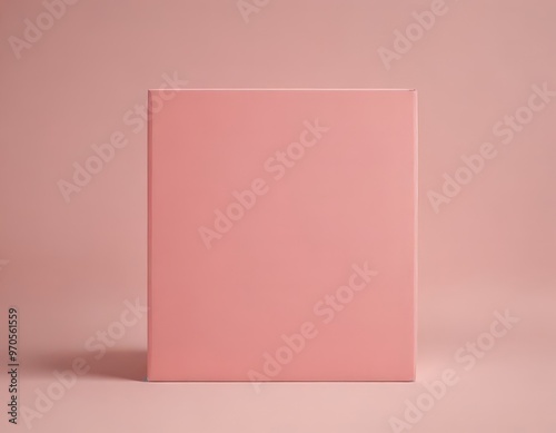 A pink book stands upright against a pink background, its cover blank and unadorned.