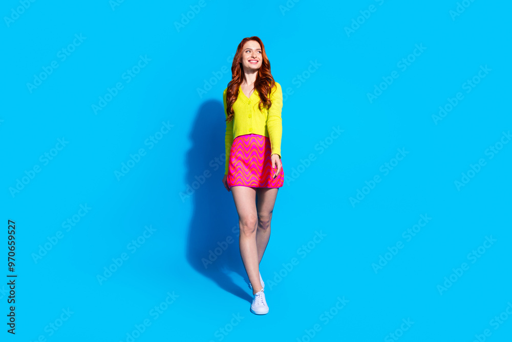 Full body photo of attractive young woman walking look empty space dressed stylish yellow clothes isolated on blue color background Full body photo of attractive young woman walking look empty space dressed stylish yellow clothes isolated on blue color background