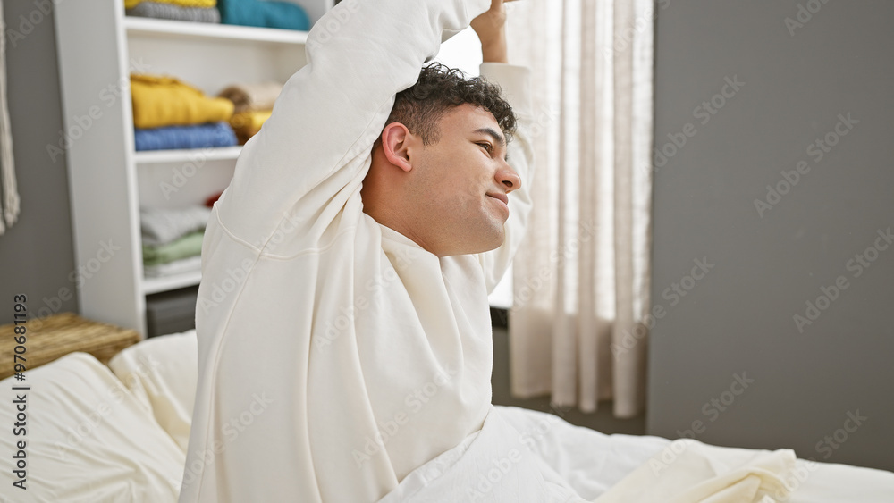 A relaxed man stretching in bed with a serene look in a bright bedroom interior. A relaxed man stretching in bed with a serene look in a bright bedroom interior.