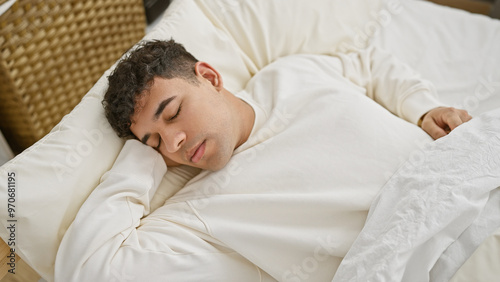 A peaceful young man sleeping comfortably in a bright bedroom setting, capturing a moment of rest in an indoor environment.