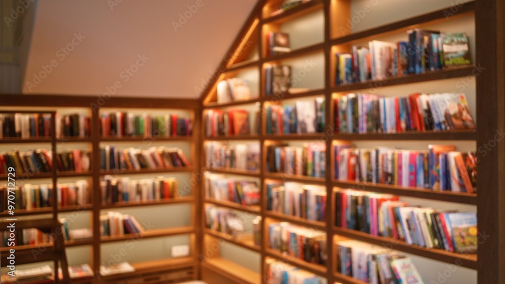 Blurred background in a library with bookshelves filled with colorful books, creating a defocused ambiance for reading and learning